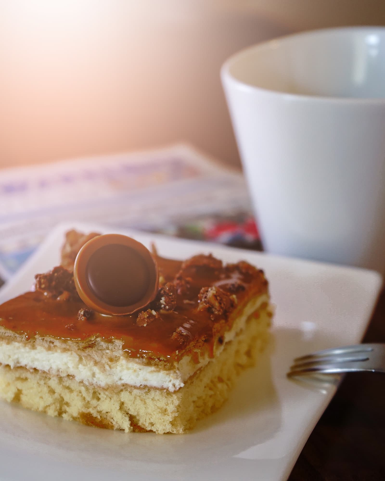 Cremeschnitte mit Karamell neben einer Tasse Kaffee